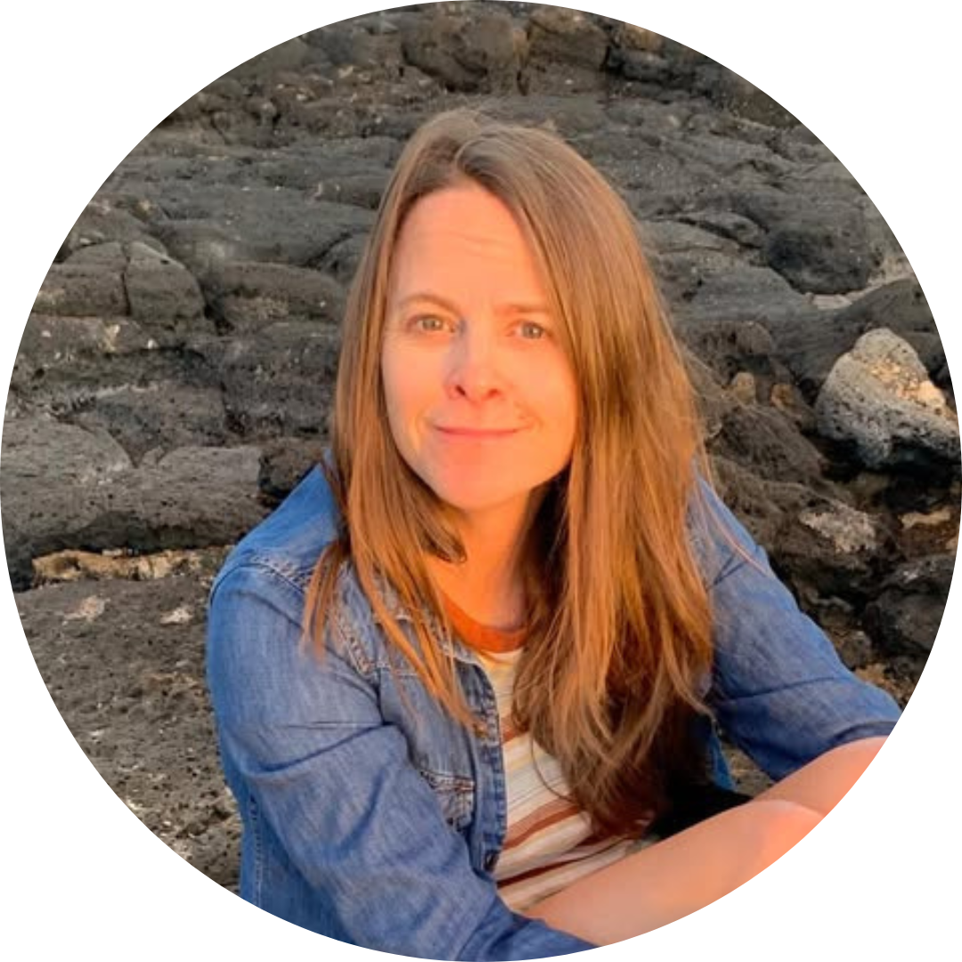 Margot LaBree, one of the students of Sustainable Happiness Together's programs with long brown hair, sitting in a denim button down shirt in front of a grey, rocky background.
