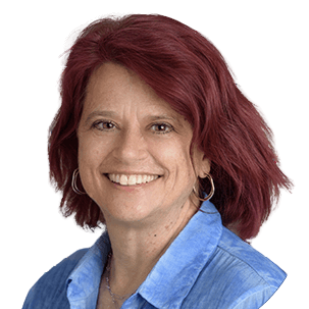 Profile picture for Paula Joy Rocha, a woman with brown eyes and red hair wearing a blue denim collared shirt and hoop earrings.