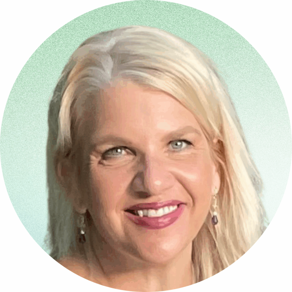 Headshot of Resilience and HeartMath® coach, Dr. Cyrina Bullard (PharmD) smiling with long blonde hair and blue eyes, wearing a purple dress in front of a light green background.
