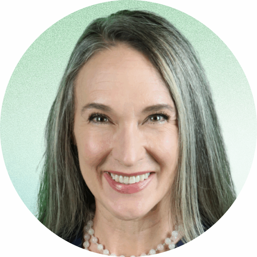 Headshot of Mindfulness Educator, Liz Rutledge with brown highlighted hair and brown eyes wearing a rose quartz mala necklace and a navy blue top in front of a light green background.